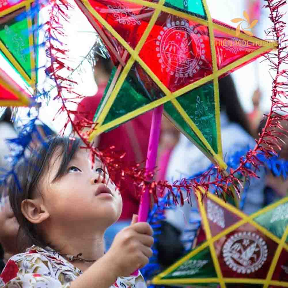 Hình ảnh em bé đang chơi lồng đèn ông sao